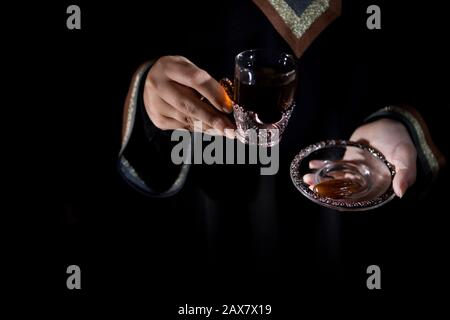 Una donna araba che tiene il gawa (caffè arabo). Foto Stock