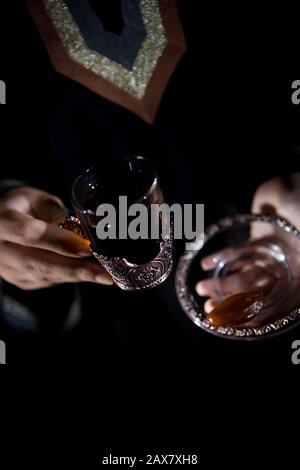 Una donna araba che tiene il gawa (caffè arabo). Foto Stock