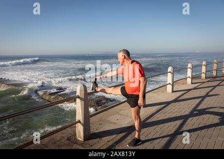 Stretching Jogger sul mare Foto Stock