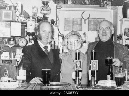 Emmerdale attori Ronald Magill (a sinistra) e Arthur Pentelow (a destra) dietro il bar nel pub White Bear a Masham, Yorkshire, con padrona di casa, Mary Gray. Foto Stock