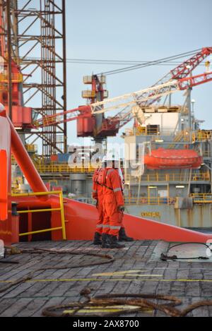 L'equipaggio marino inizia l'operazione di movimentazione dell'ancora sul ponte per il carro di sollevamento Foto Stock