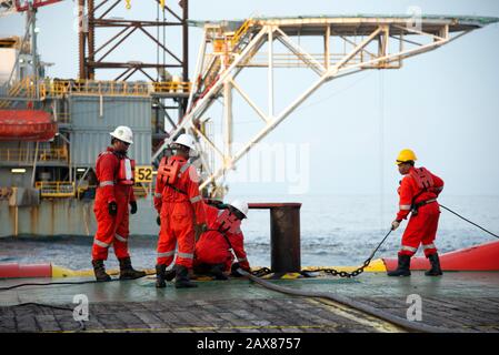 L'equipaggio marino inizia l'operazione di movimentazione dell'ancora sul ponte per il carro di sollevamento Foto Stock