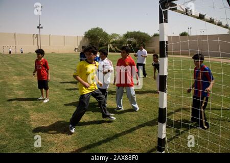 Gli studenti potranno giocare a calcio durante la loro lezione di PE presso la Kingdom School di Riyadh, Arabia Saudita. Foto Stock