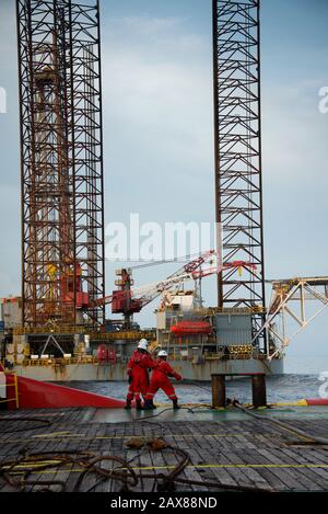 L'equipaggio marino inizia l'operazione di movimentazione dell'ancora sul ponte per il carro di sollevamento Foto Stock