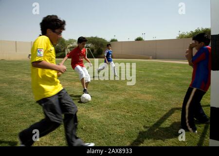 Gli studenti potranno giocare a calcio durante la loro lezione di PE presso la Kingdom School di Riyadh, Arabia Saudita. Foto Stock