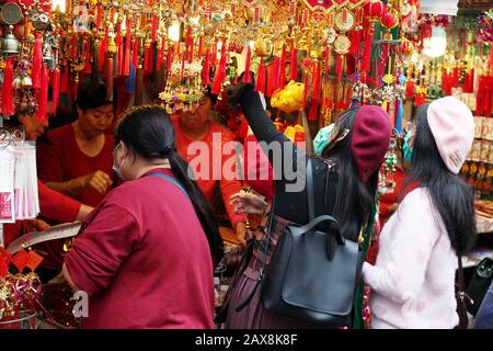 Acquirenti con Maschere Facciali Alle Bancarelle del tempio di Wong Tai Sin, Hong Kong durante Lo Scoppio di Coronavirus, 2020. Foto Stock