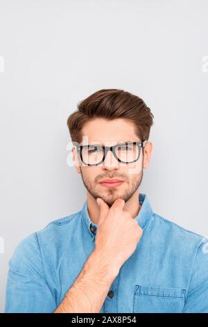 Ritratto di uomo intelligente ponder in occhiali che toccano il mento Foto Stock