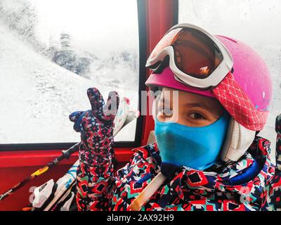 Cabina di guida per famiglie in funivia sulle piste da sci invernali. Famiglia in vacanza invernale sci viaggio prendere selfie all'interno di cabina con splendida vista sulle montagne Foto Stock