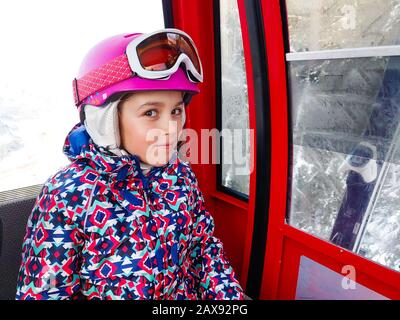 Cabina di guida per famiglie in funivia sulle piste da sci invernali. Famiglia in vacanza invernale sci viaggio prendere selfie all'interno di cabina con splendida vista sulle montagne Foto Stock