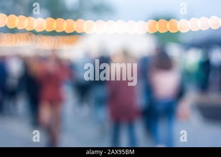 Immagine sfocata di affollate outdoor street festival. Lampade e la gente lo sfondo. Foto Stock