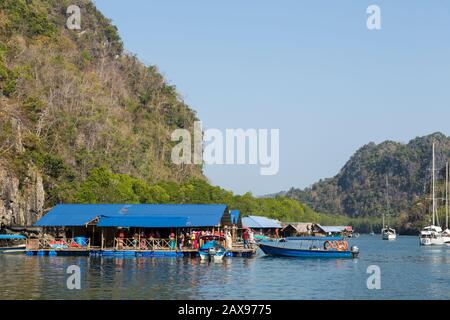 Le barche portano turisti musulmani all'allevamento di pesci Paksu, al parco geoforest di Karst Karst, Langkawi, Malesia