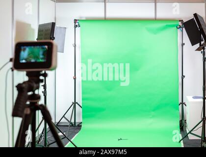 Sfondo studio con schermo verde. Set da studio per riprese o fotografie con luci e attrezzature per riprese Foto Stock