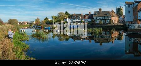 24 Ottobre 2018 - Tewkesbury, UK: Un uomo scatta una foto di un pittoresco gruppo di cottage che si riflettono nel tranquillo fiume Avon vicino Abbey Mill nella città di Tewkesbury, Gloucestershire, Severn vale, UK Foto Stock