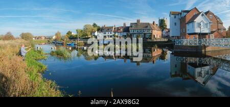 24 Ottobre 2018 - Tewkesbury, UK: Un uomo scatta una foto di un pittoresco gruppo di cottage che si riflettono nel tranquillo fiume Avon vicino Abbey Mill nella città di Tewkesbury, Gloucestershire, Severn vale, UK Foto Stock