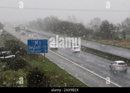 Moira, Nord, Irlanda. 11th Feb, 2020. Tempo nel Regno Unito - docce di neve diffusa in tutta l'Irlanda del Nord a tutti i livelli. Forti venti dopo Storm Ciara creando condizioni simili a quelle di una beatitudine. Traffico autostradale sulla M1 a Moira durante un'altra doccia di neve pesante. Credito: David Hunter/Alamy Live News Foto Stock