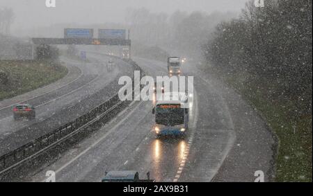 Moira, Nord, Irlanda. 11th Feb, 2020. Tempo nel Regno Unito - docce di neve diffusa in tutta l'Irlanda del Nord a tutti i livelli. Forti venti dopo Storm Ciara creando condizioni simili a quelle di una beatitudine. Traffico autostradale sulla M1 a Moira durante un'altra doccia di neve pesante. Credito: David Hunter/Alamy Live News Foto Stock