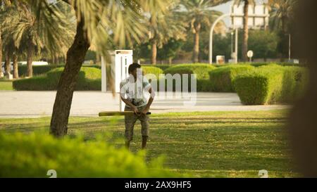 Ragazzo indiano che gioca a cricket a Dubai, Emirati Arabi Uniti. Foto Stock