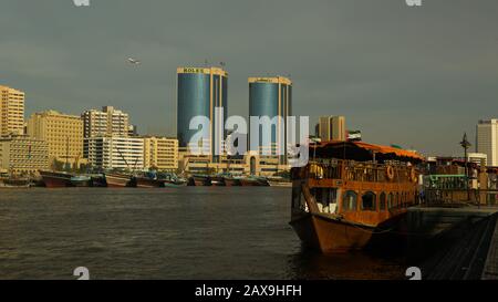 Dhow tradizionale di fronte alle Rolex Towers a Dubai Creek, Dubai, Emirati Arabi Uniti. Foto Stock