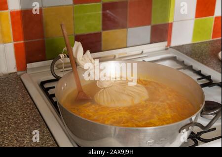 Bollendo giù le arance di Siviglia in un grande marmellata o marmellata che fa la vaschetta che simmering fuori dell'acqua eccedente con il sacchetto di muslin contenente la fonte dei semi di pectina pips Foto Stock