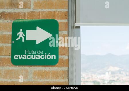 segnale del percorso di evacuazione, testo in spagnolo. Foto Stock