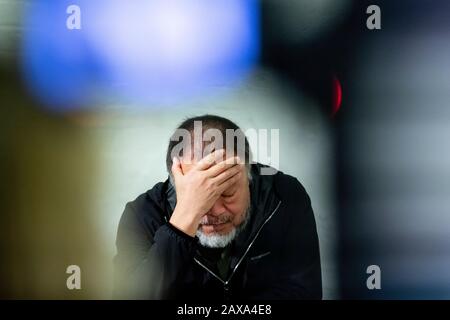 Berlino, Germania. 11th Feb, 2020. L'artista cinese ai Weiwei sostiene la testa in una mano quando presenta le sue opere d'arte 'Giacche di sicurezza Zipped il Contrario' nel suo studio. Le varie costruzioni di giacche di sicurezza, ganci e barre di ferro possono essere acquistate come parti individuali dallo sponsor Hornbach e assemblate da parti interessate stesse. Credit: Christoph Soeder/Dpa/Alamy Live News Foto Stock