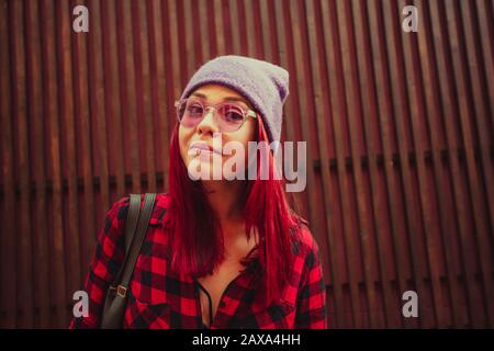 Giovane ragazza hippster con pittura capelli rossi e piercing sulle labbra Foto Stock