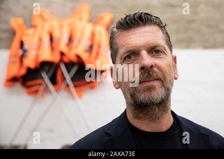 Berlino, Germania. 11th Feb, 2020. Karsten Kühn, Chief Marketing and Human Resources Officer di Hornbach, si trova nello studio dell'artista cinese ai Weiwei durante la presentazione della sua opera "Safety Jackets Zipped the Other Way". In background è possibile vedere l'impianto nel "supporto versione". Le varie costruzioni di giacche di sicurezza, ganci e barre di ferro possono essere acquistate come parti individuali dallo sponsor Hornbach e assemblate da parti interessate stesse. Credit: Christoph Soeder/Dpa/Alamy Live News Foto Stock