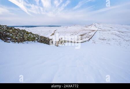 Ampio spazio vuoto nella neve coperta paesaggio invernale intorno al Vallo di Adriano mentre si estende verso Sewingshield Craig, Northumberland, Inghilterra nord-orientale Foto Stock