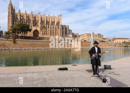 Mallorca, Spagna - 8 maggio 2019: Musicista di strada sul lungomare accanto alla Cattedrale di Palma di Maiorca. Isola Di Maiorca, Isole Baleari, Spai Foto Stock