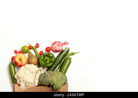 Sacchetto di carta di diversi ortaggi e frutta agricoli sani isolato su uno sfondo bianco. Vista dall'alto. Disposizione piatta con spazio di copia. Foto Stock