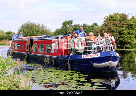 Le persone in una chiatta che si godono una gita di un giorno sul fiume Librano, vicino Barrow on Soar, Leicestershire, Inghilterra, Regno Unito. Foto Stock