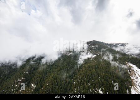 Paesaggio alpino di montagna a Isola 2000 nelle alpi francesi. Bassa nubi appese intorno alle cime di montagna. Foto Stock