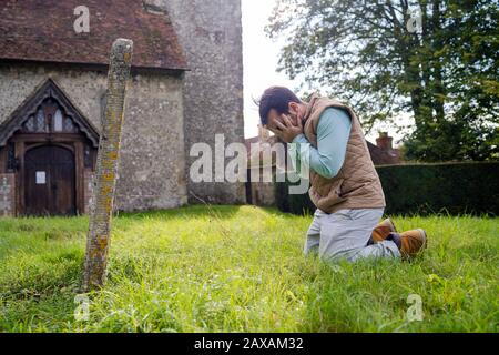 Un giovane addolorata davanti alla lapide sul vecchio cimitero Foto Stock