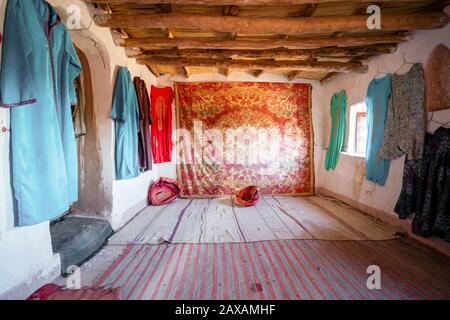 Interno di una camera storica decorata con tappeti berberberi e vestiti in argilla città di Ait ben Haddou, Marocco Foto Stock