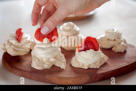 Il processo di creazione di Pavlova dessert, decorazione della meringa Foto Stock