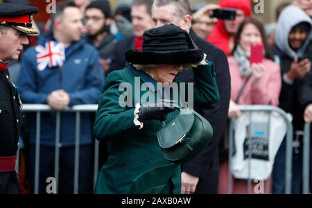 La duchessa di Cornovaglia tiene sopra al suo cappello mentre arriva per una visita al mercato di Leicester. Foto Stock