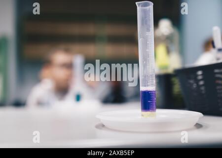 Bambini che lavorano in classe chimica. Concetto di istruzione scolastica. Provetta in vetro riempita con liquido viola Foto Stock