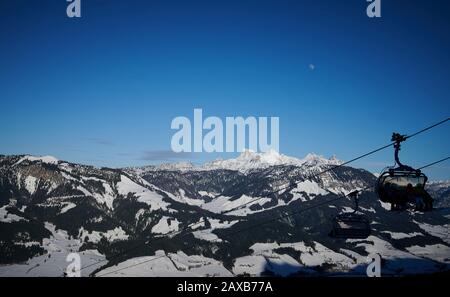 Sankt Johann In Tirol, Austria. 06th Feb, 2020. Dietro una seggiovia, il cielo blu e la luna brillano sulla cima innevata della montagna in sterreich. Credito: Annette Riedl/dpa-Zentralbild/ZB/dpa/Alamy Live News Foto Stock