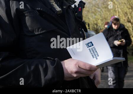 Denham, Regno Unito. 11 Febbraio 2020. Un ufficiale della polizia della Thames Valley legge da un libro intitolato ’Controterrorismo Policing’ mentre emette un avvertimento a un attivista ambientale di Extinction Rebellion che era stato ‘sa piedi bassi’ di fronte a un HGV che trasportava un veicolo elevatore JCB in un sito HS2. L'attivista è stato successivamente arrestato. Credit: Mark Kerrison/Alamy Live News Foto Stock