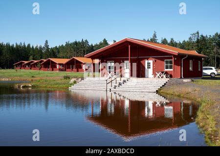 Chalet per vacanze sul lago dipinti in legno rosso al Kosta Lodge Foto Stock