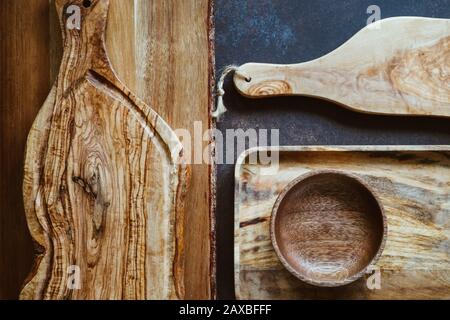 Vista dall'alto su rustici utensili in legno. Tagliere e cucchiai. Concetto di cucina ecologica e naturale. Foto Stock