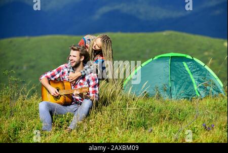 Aria fresca e sensazioni pure. Coppia in amore felice rilassante sfondo natura. Fidanzata chitarra vicino tenda campeggio. Vacanze estive. Vacanza in campeggio. Escursioni romanticismo. Campeggio in montagna. Foto Stock