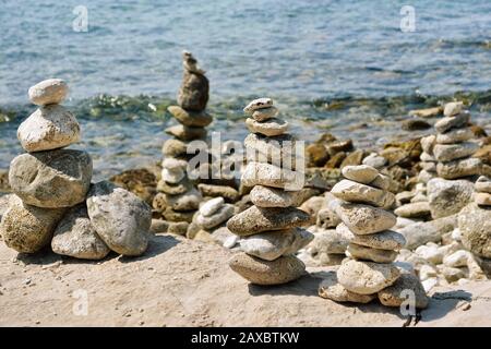 Piramidi di pietre sulla costa rocciosa del mare Adriatico in Croazia. Sullo sfondo delle onde marine. Foto Stock
