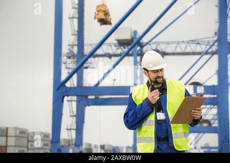 Collega con walkie-talkie e appunti presso il cantiere Foto Stock