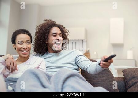 Coppia felice rilassante, guardando la TV sul divano soggiorno Foto Stock