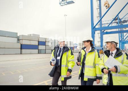 I lavoratori portuali e il manager camminano e parlano al cantiere Foto Stock