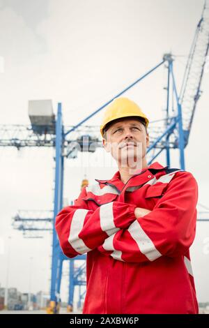 Operatore di ormeggio sicuro sotto la gru presso il cantiere Foto Stock
