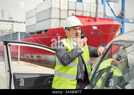 Dock manager che utilizza walking-talkie presso il cantiere navale Foto Stock