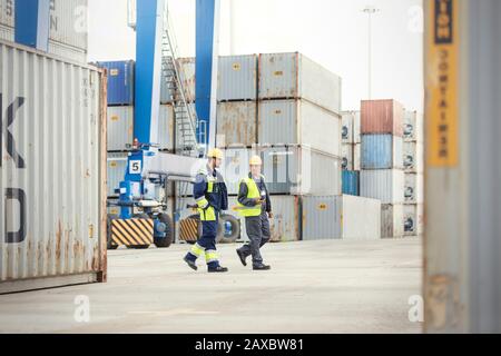 Attracca i lavoratori che camminano e parlano al cantiere Foto Stock