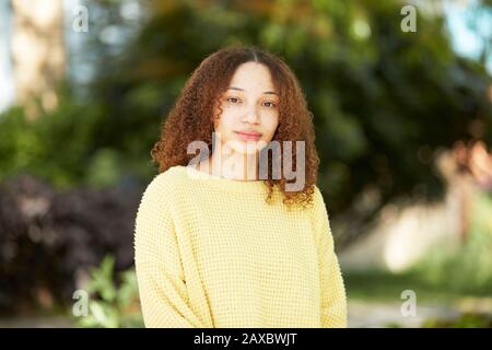 Ritratto giovane donna sicura in maglione giallo Foto Stock